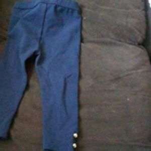 Navy blue leggings with gold buttons at the ankles
